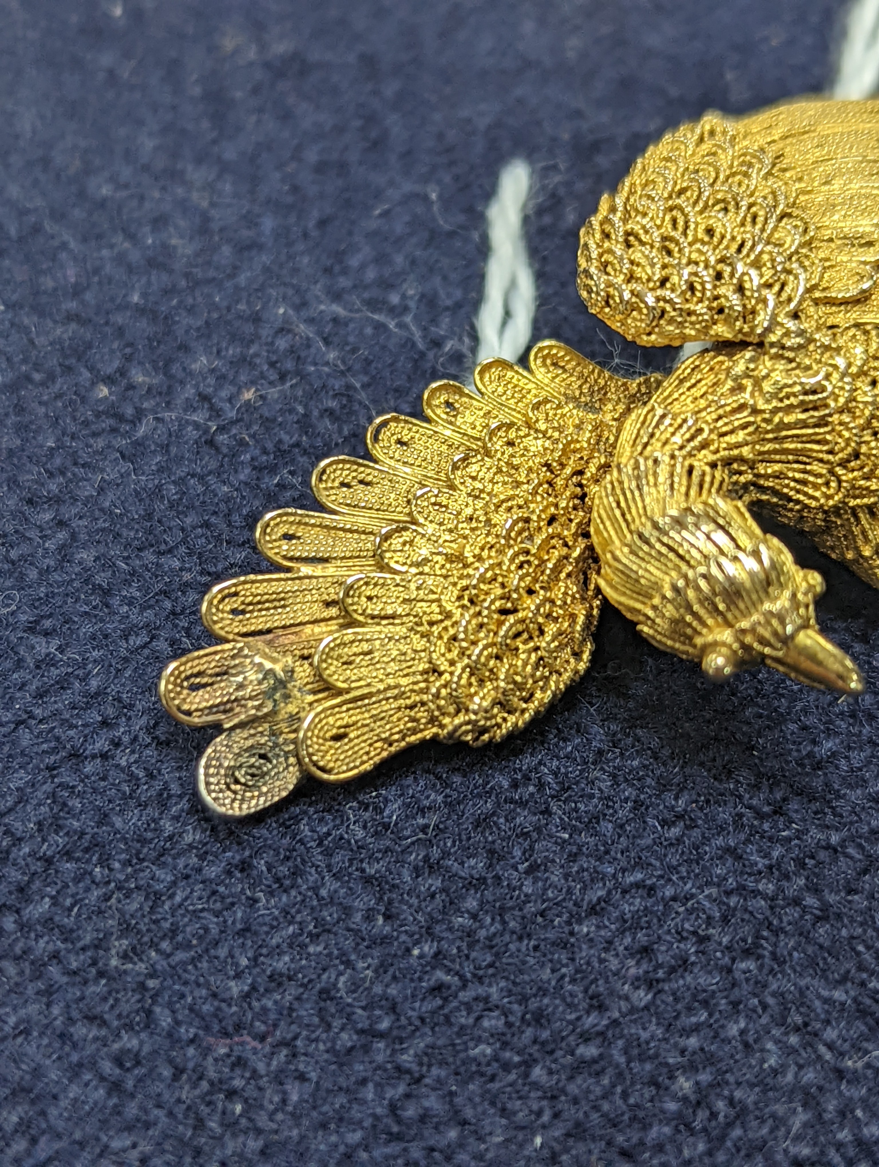 A Chinese filigree yellow metal eagle brooch, stamped 'WS 20 (with character marks)', 36mm, gross 6.5 grams.